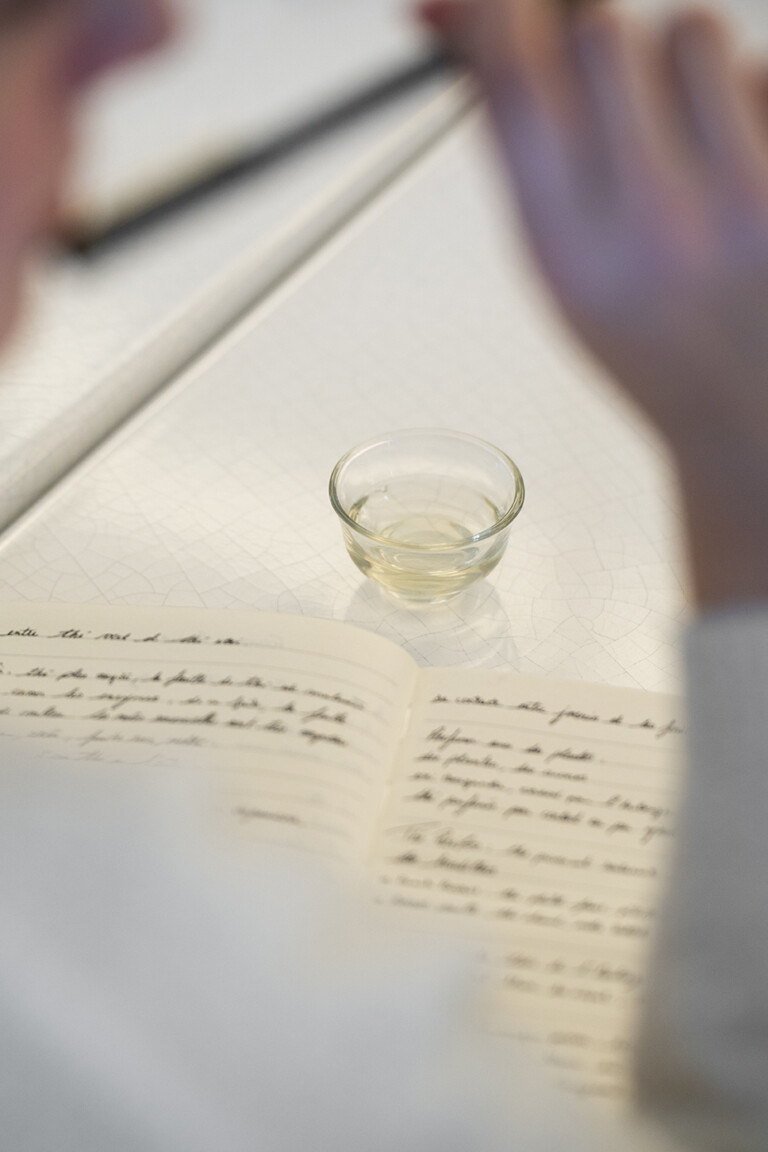 Carnet de notes manuscrites et tasse de liqueur claire