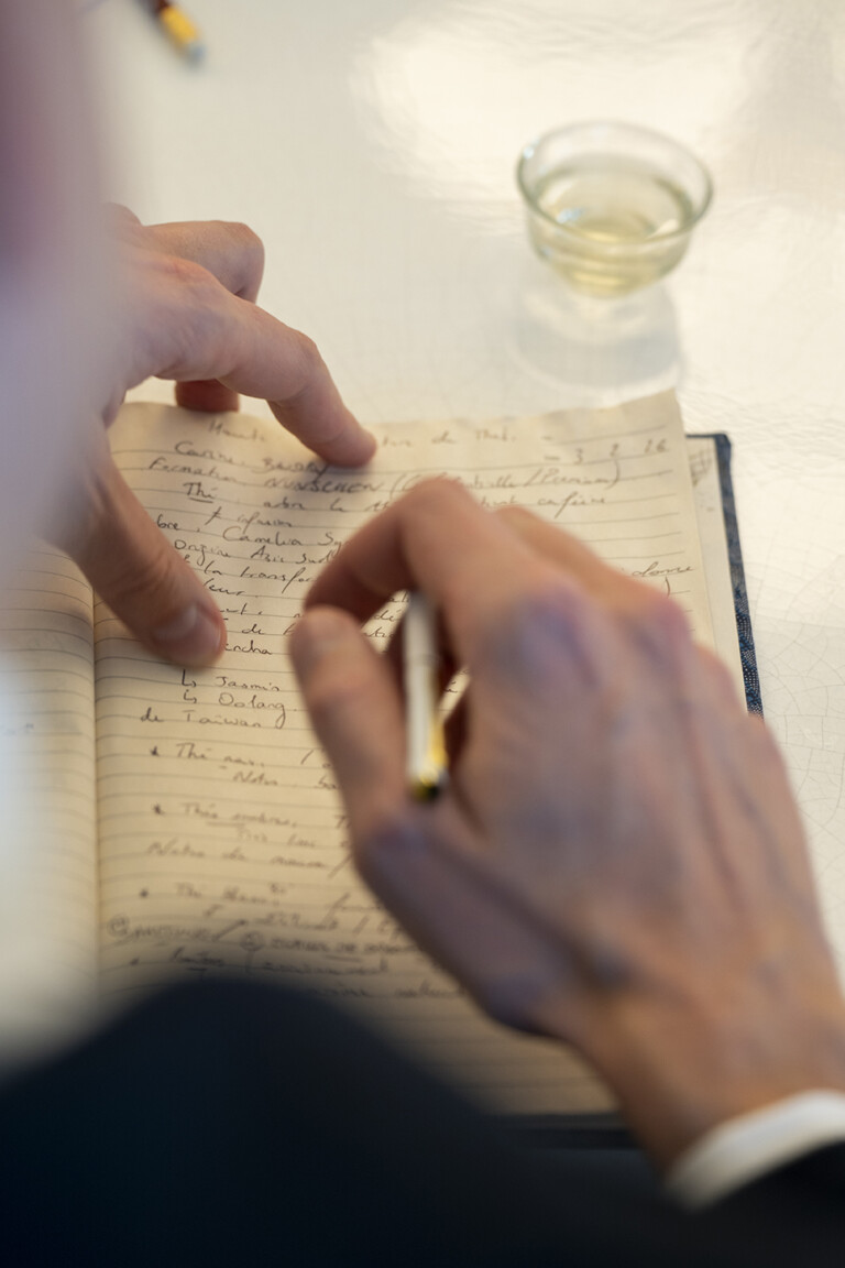 Mains prenant des notes de dégustation dans un carnet
